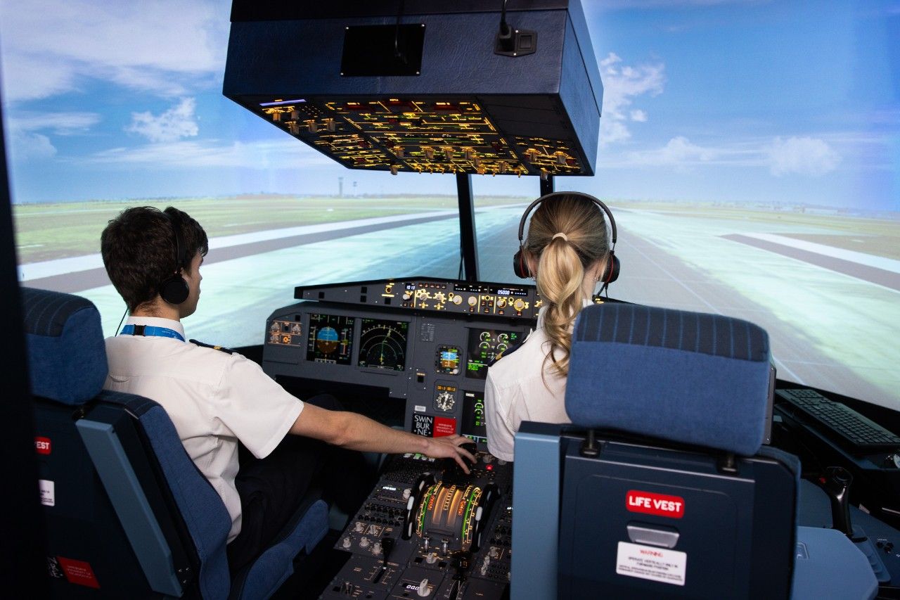 A male and female student training as pilot and copilot in Swinburne’s flight simulator.