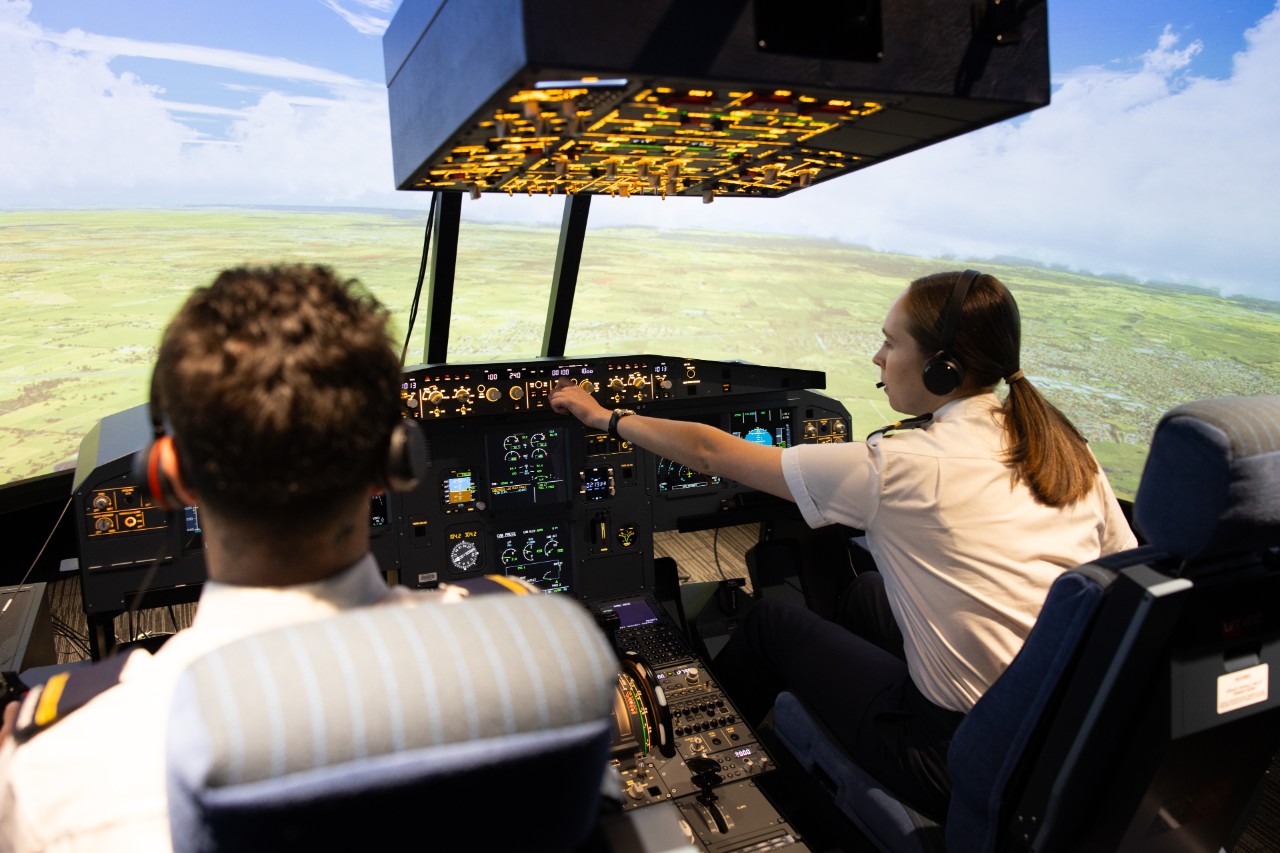 Final-year piloting students practicing multi-crew cooperation in the A320 simulator to build teamwork and SOP skills.