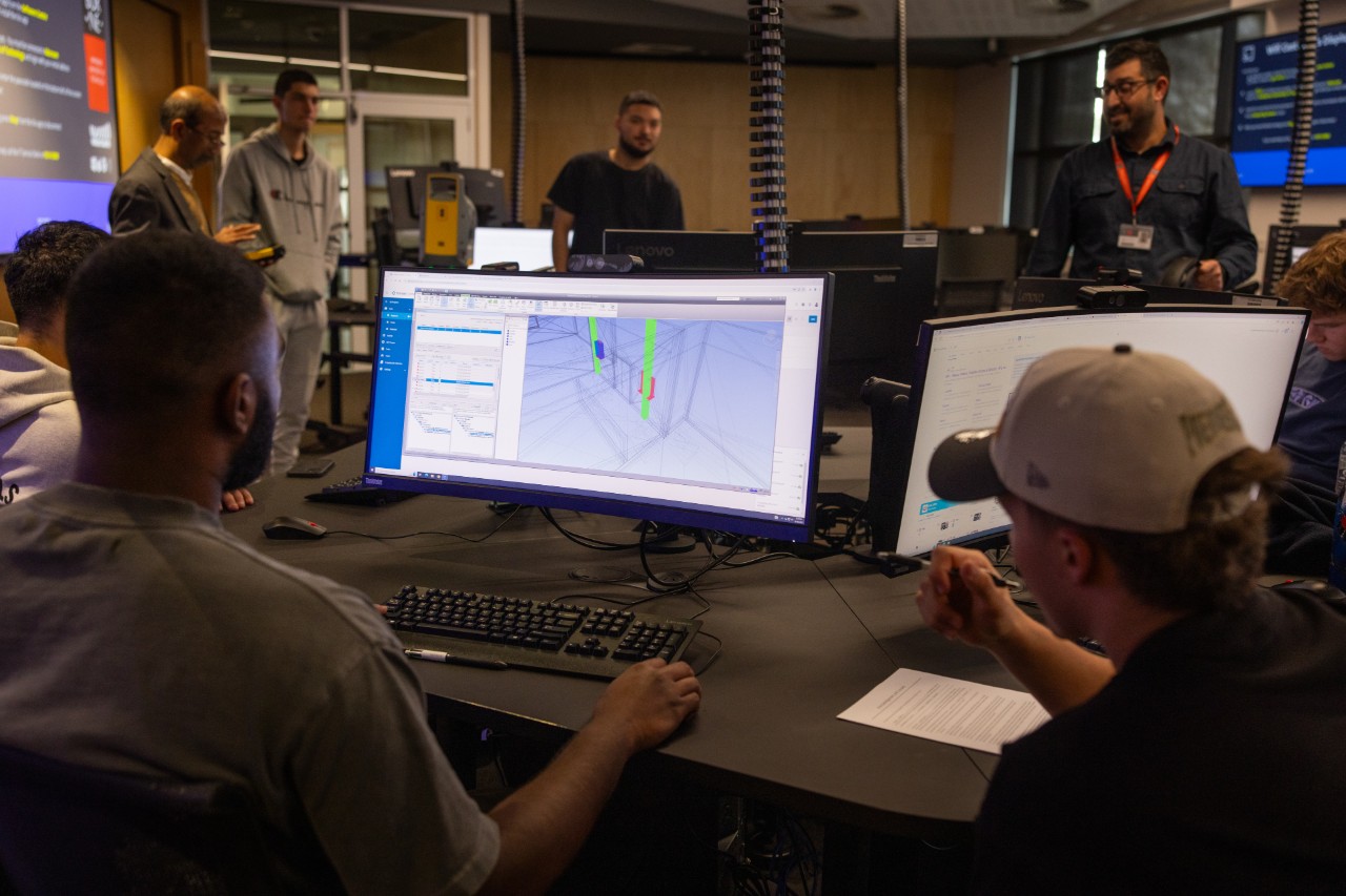 Students and staff using advanced 3D software to review and coordinate building designs.