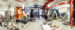 A wide shot of one room of the Digital Construction Lab showing a large 3D concrete printer and large industrial robot.
