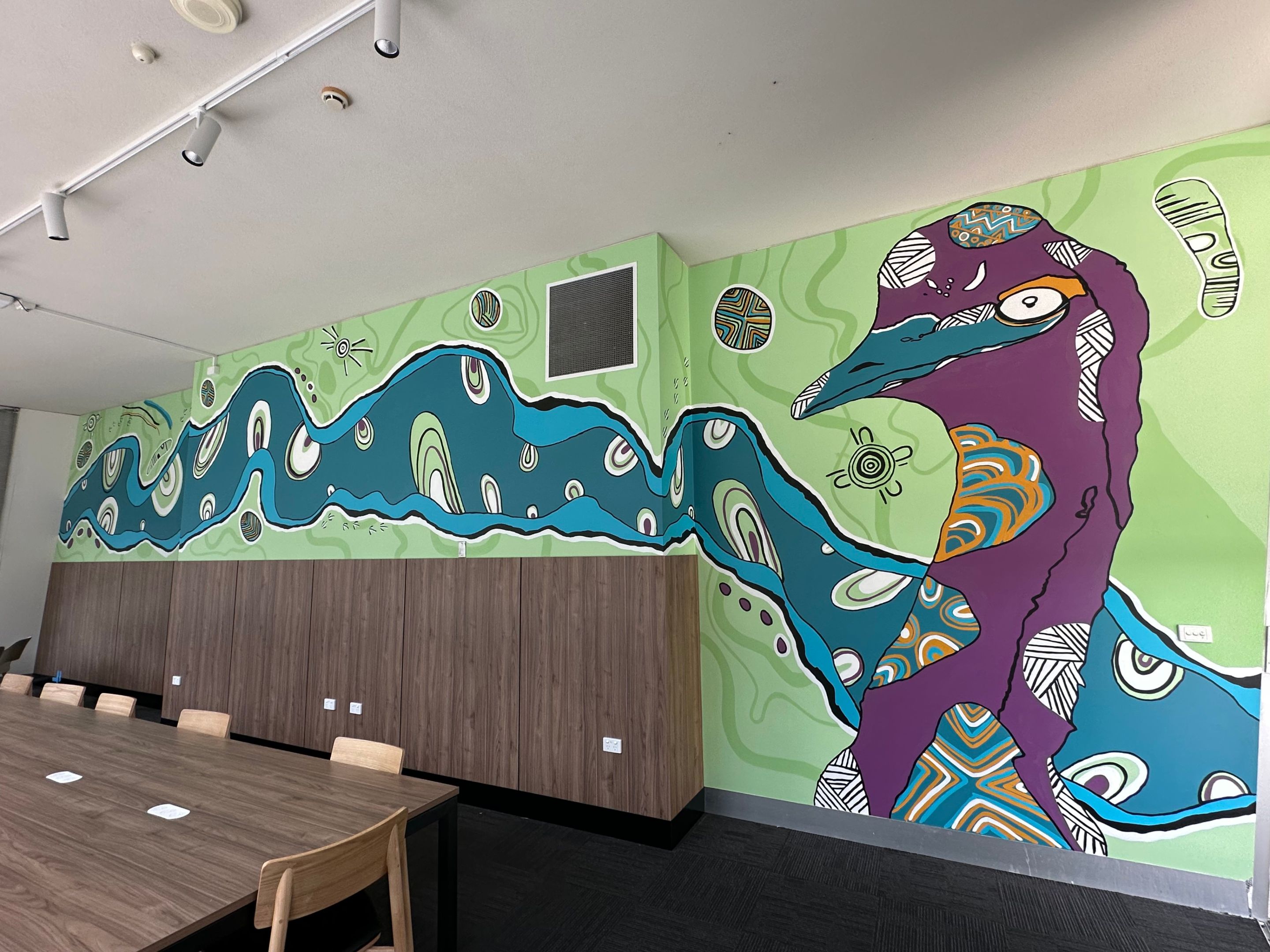 Indigenous artwork by Mandi Barton, featuring an emu, bright colours and flowing lines along a wall. 