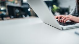 female typing on laptop close-up