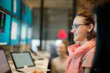 Female student with her laptop talking to an adviser 