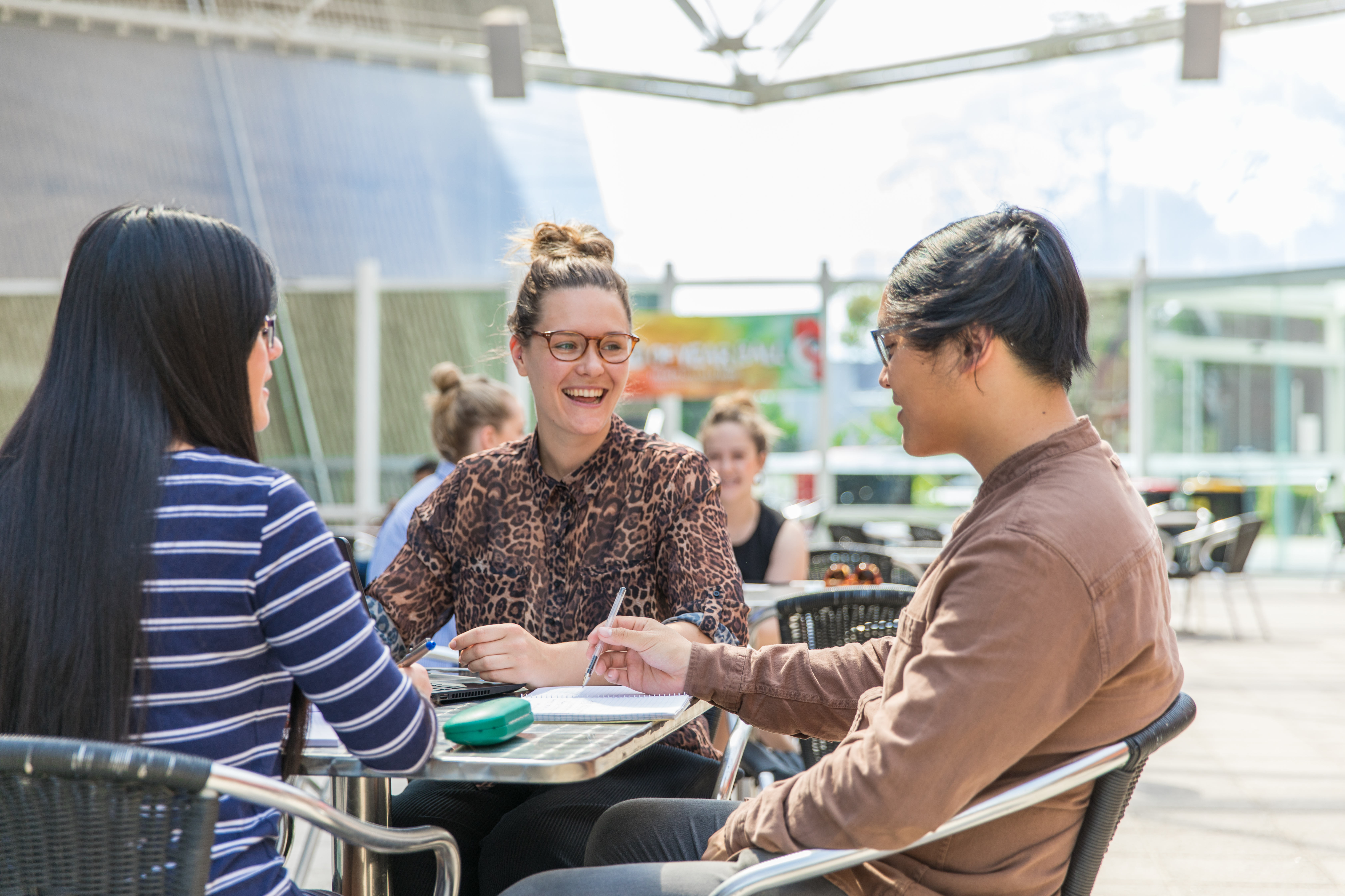 Three people sitting at a table talking