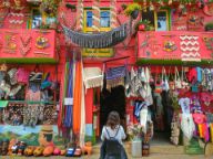 Woman standing out the front of a bight coloured market shop stall in Colombia