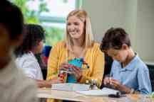 Science teacher and students studying solar system in class