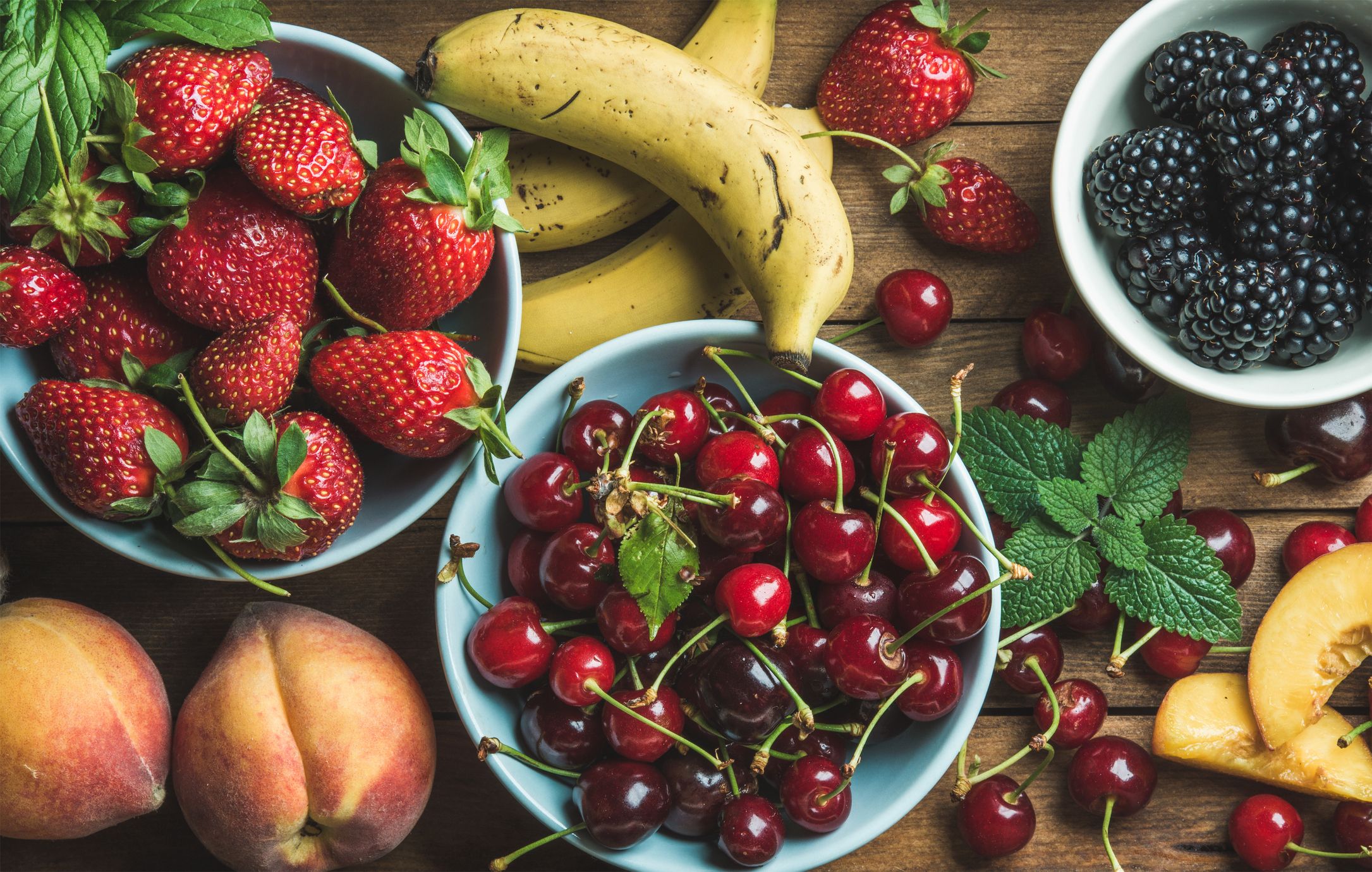 Summer fresh fruit and berry variety over wooden backdrop