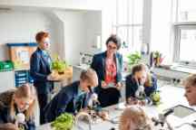 A teacher looking over students while they work on a microbiology lesson