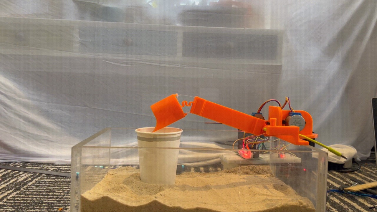 BICEP is attched to a glass box filled with sand where it is displaying the manoeuvrability of the cup shaped scooper 