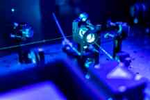 Laser reflection on optic table in quantum laboratory.