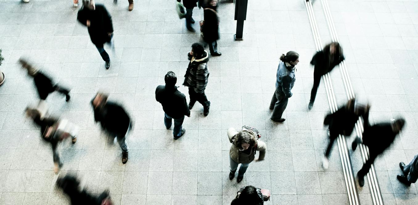 Crowd of people walking around, some are blurry with a long shutter speed effect