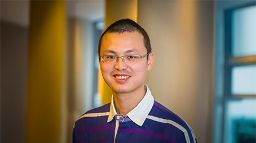 Portrait of a person wearing glasses, smiling slightly.