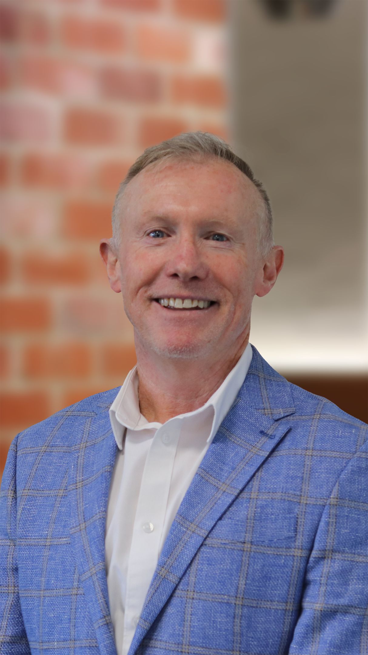Man in a blue blazer smiling at the camera 