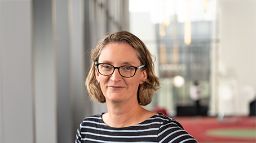 Portrait of a person wearing glasses, smiling slightly.