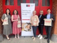 Professionals, academics and researchers standing in front of banner