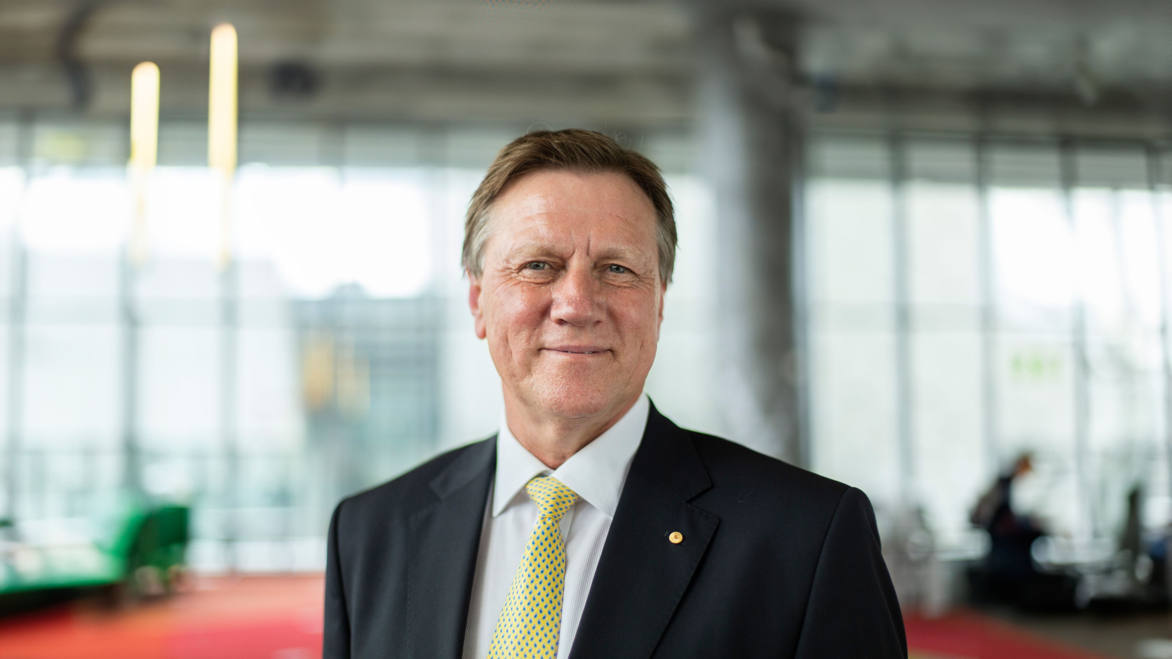 Swinburne University Chancellor, John Pollaers, smiles to camera in The George building of the Hawthorn campus