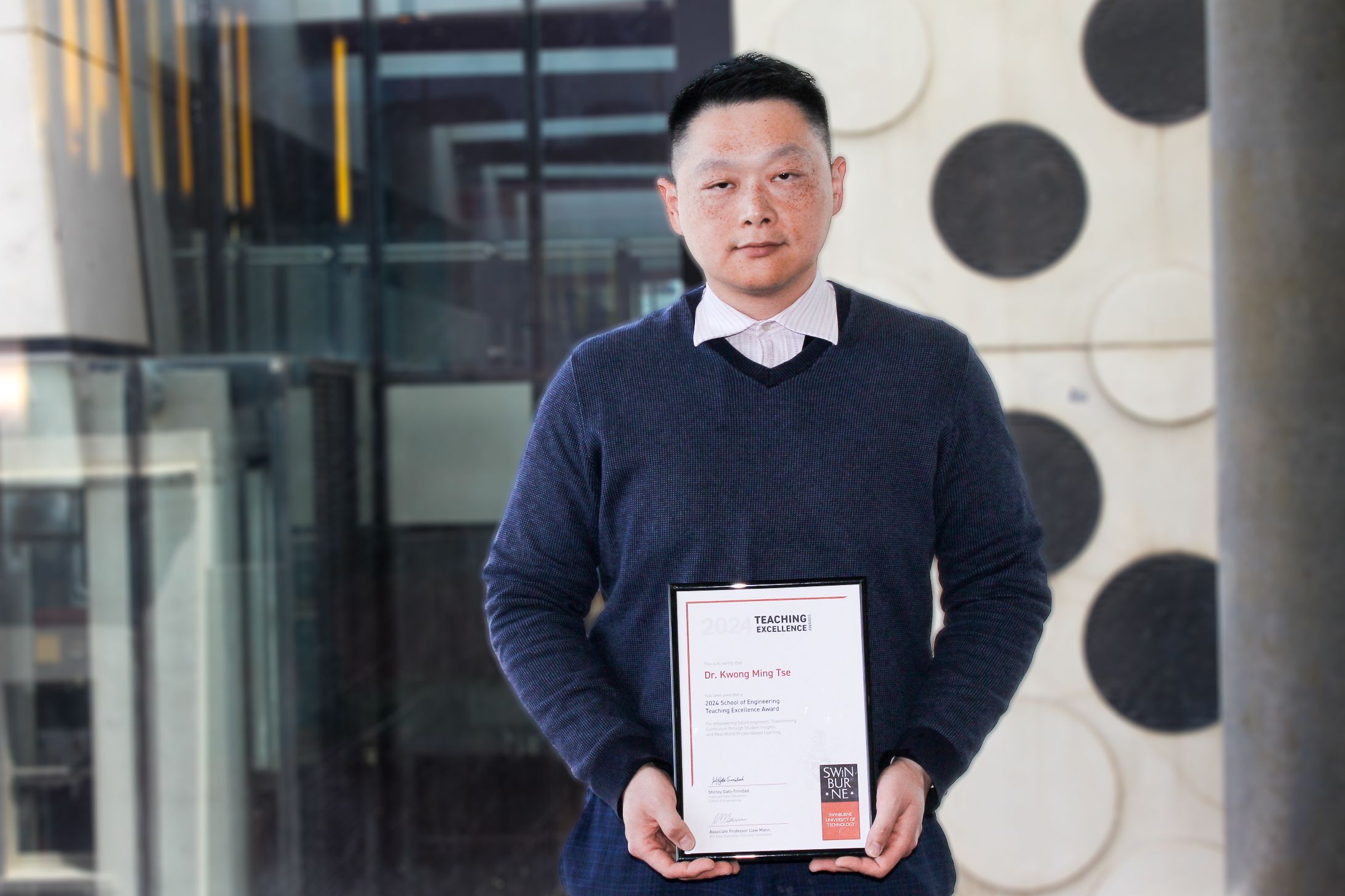 Dr Kwong Ming Tse holding his School Teaching Excellence Award