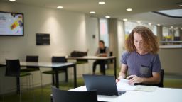 Student studying with laptop at desk in AMDC building level 6