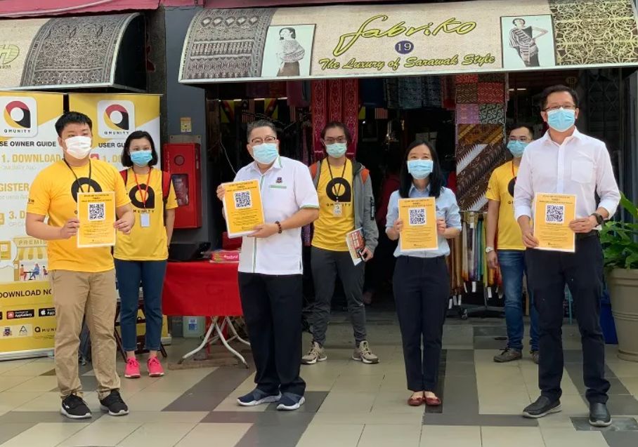 Sarawak community holding QR code for Qmunity COVID-19 tracking app