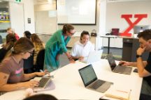 A group of design students collaborating with a staff member in class