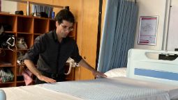 Kamal, a Certificate IV of Community Services student, preparing a hospital bed.