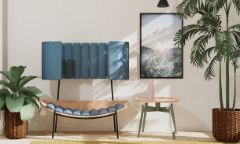 A lounge chair featuring timber and blue cylindrical seat cushions and back support features in a room along with indoor plants and a coffee table