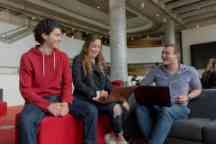 Three students studying and chatting discussing an assignment within a building in the Hawthorn campus