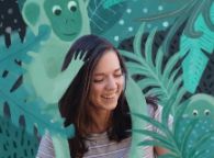 Georgia surrounded my illustrated green plants and a green monkey sitting on her shoulders