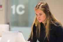 Female student working on her laptop in the library