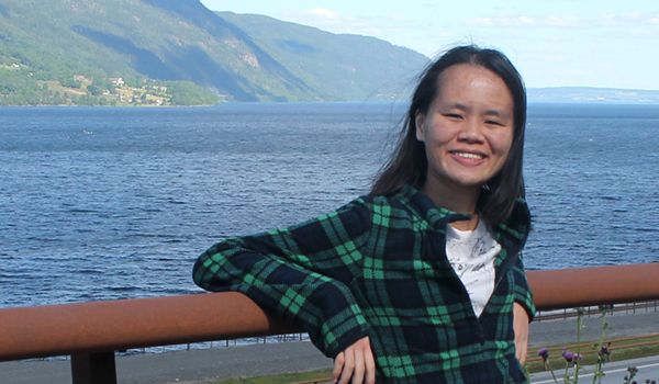 Photograph of Swinburne alumna Phui Jing Ling standing outdoors near a body of water.