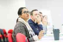 students at a desk listening to their lecturer 