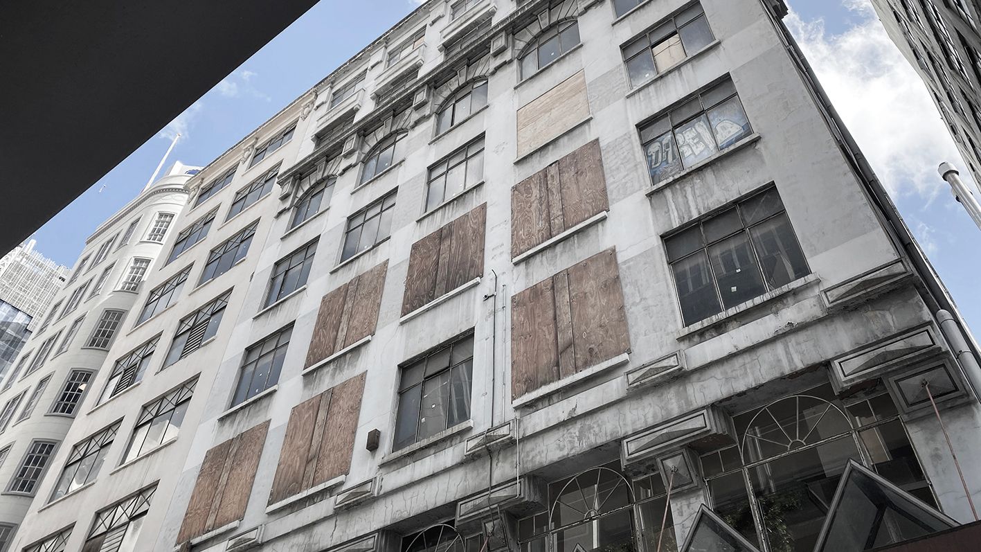 Looking up at a derelict building with boarded up windows in the Walk Arcade, Melbourne.