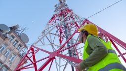 Female Engineer working on the field near a Telecommunications tower.