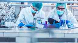 Two biotechnologists examining data for medical research in the laboratory.