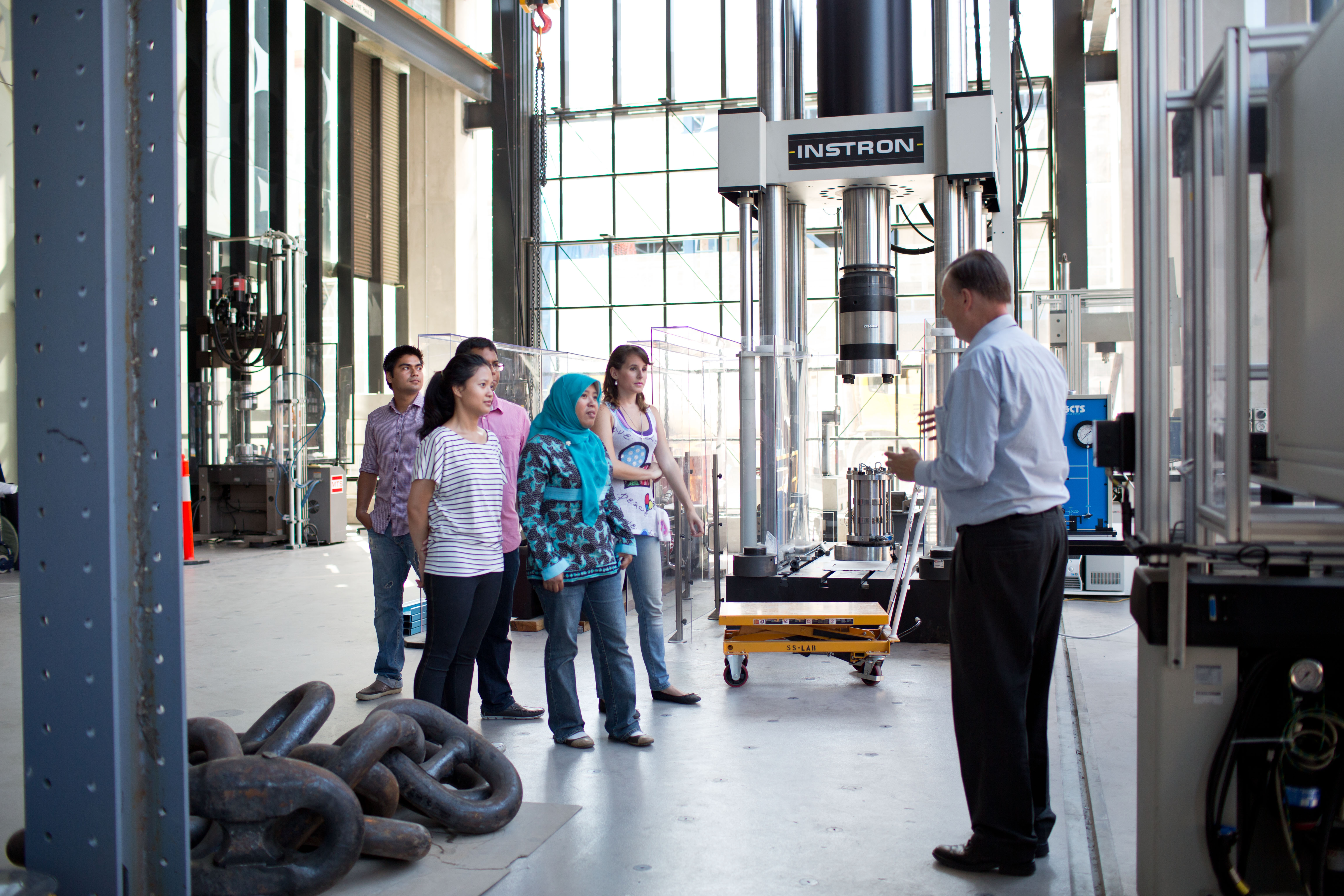 A group of students are talking to a researcher at the ATC building Smart Structures Lab